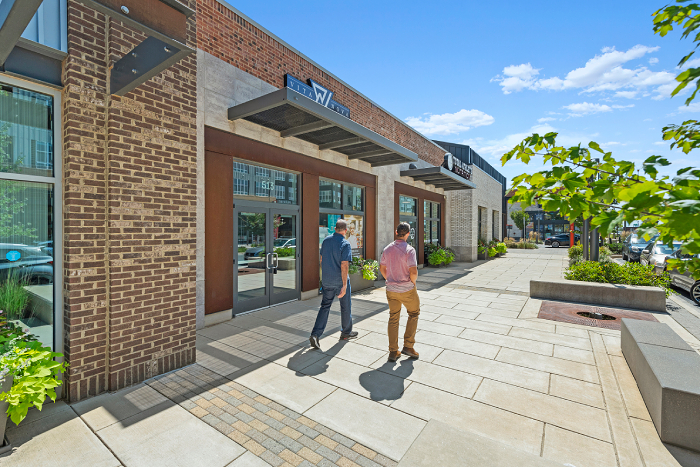 Two men walking down the Yard 56 plaza